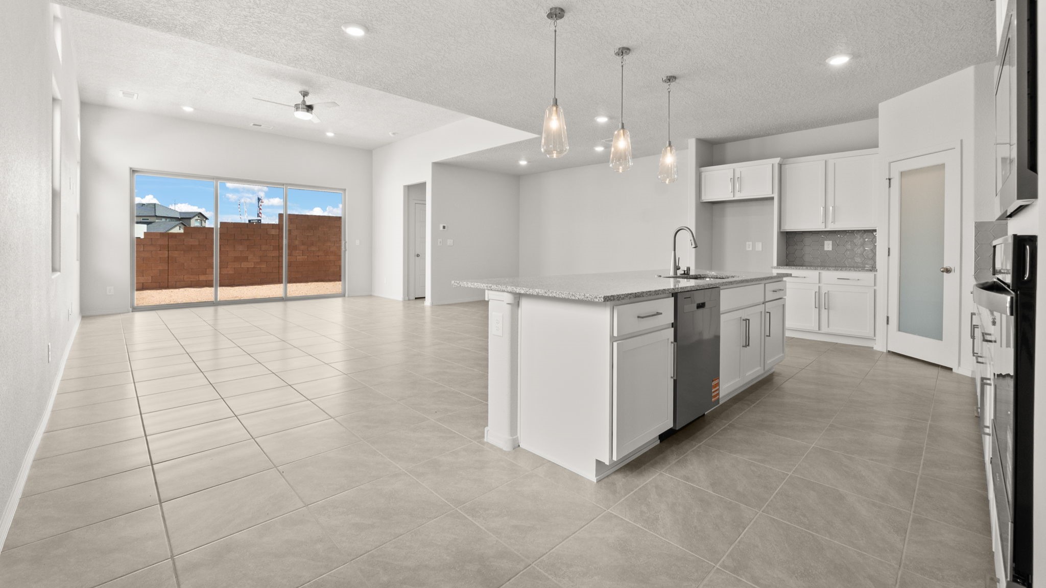 Kitchen with white cabinets, stainless steel appliances, and white and grey countertops.