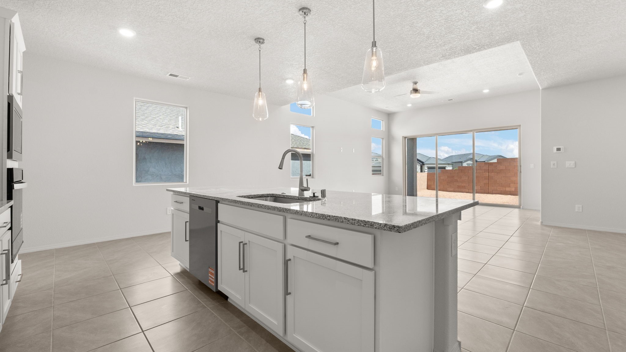 Kitchen with white cabinets, stainless steel appliances, and white and grey countertops.
