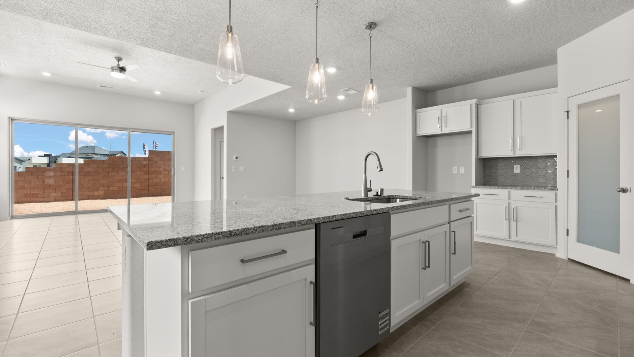 Kitchen with white cabinets, stainless steel appliances, and white and grey countertops.