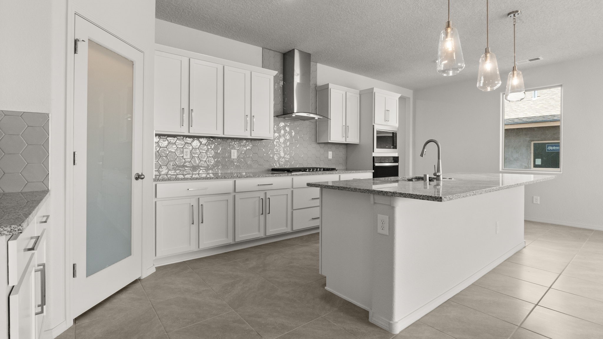 Kitchen with white cabinets, stainless steel appliances, and white and grey countertops.