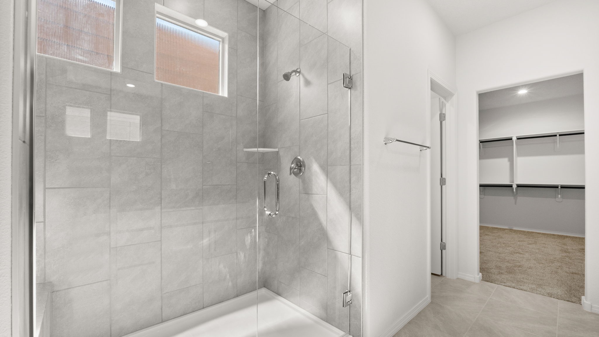 Bathroom with a walk in shower, walk in closet, and a separate door for toilet.