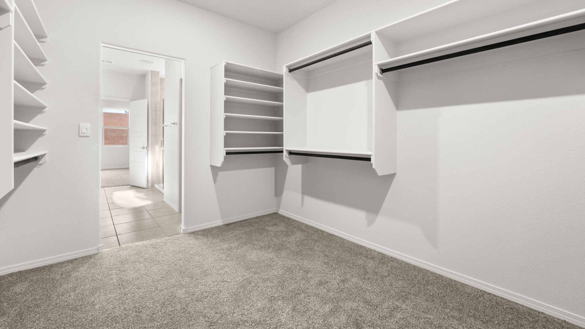 Walk in closet with built in shelving and hanging rods.