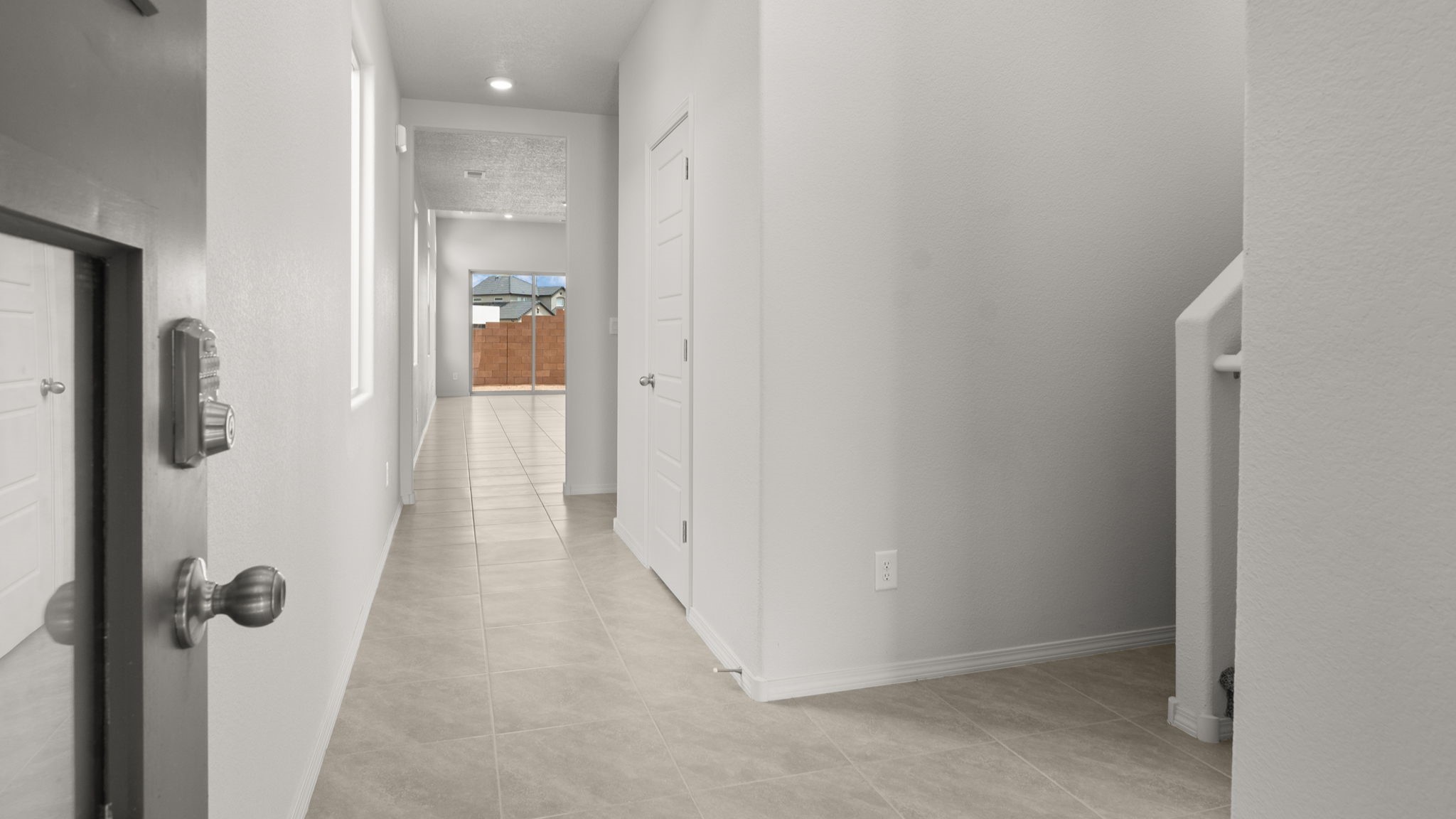 Entry way with white walls and light brown tile.