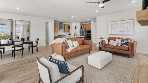 The destin living room with tile floors, modern rectangle fireplace, with sliding glass door leading to the backyard and covered patio.