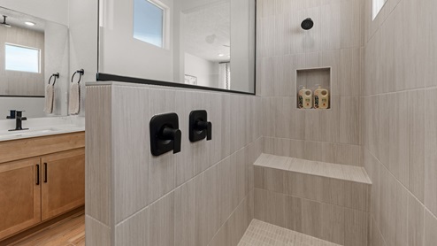 The Destin Primary Bathroom with dual vanity and two sinks, snail shower with glass, and bench