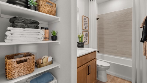 Bathroom 2 with storage shelves, single vanity sink, and tub shower combo, with tile surrounds.
