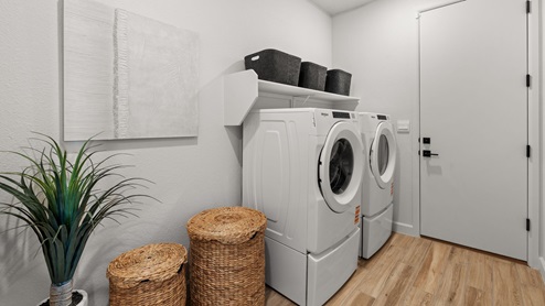 Utility room with washer and dryer. Door leading to tandem garage.