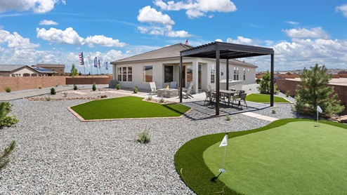 Model home backyard with outdoor kitchen, fire pit.pergola, and turf