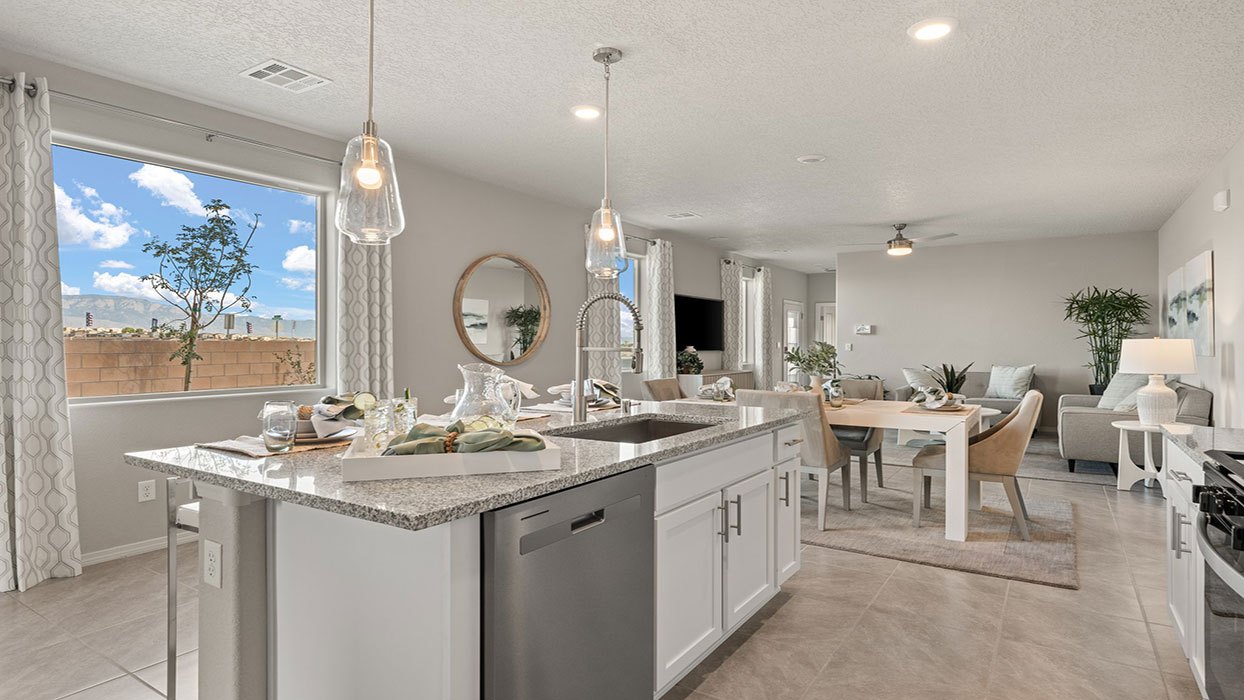 Kitchen island with sink, appliance suite included, pantry access, and added storage at Los Diamantes Phase III