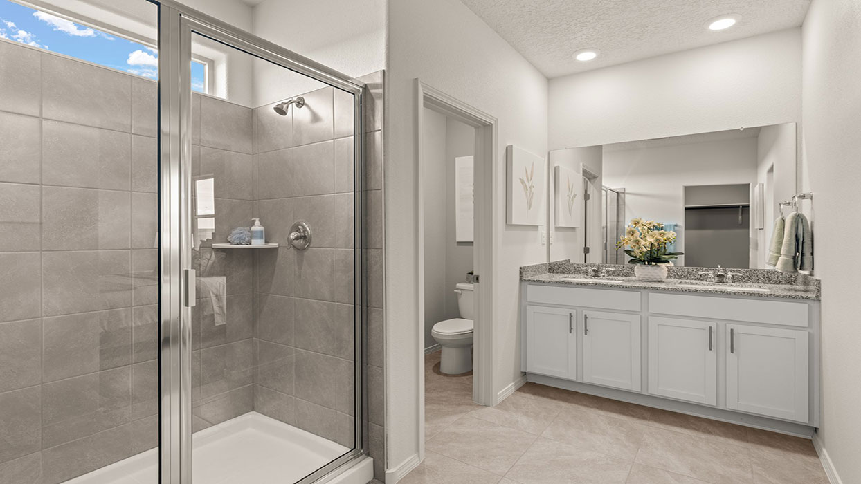 Owner ensuite walk-in shower featuring tile surround, glass enclosure, and upgraded fixtures at Los Diamantes Phase III