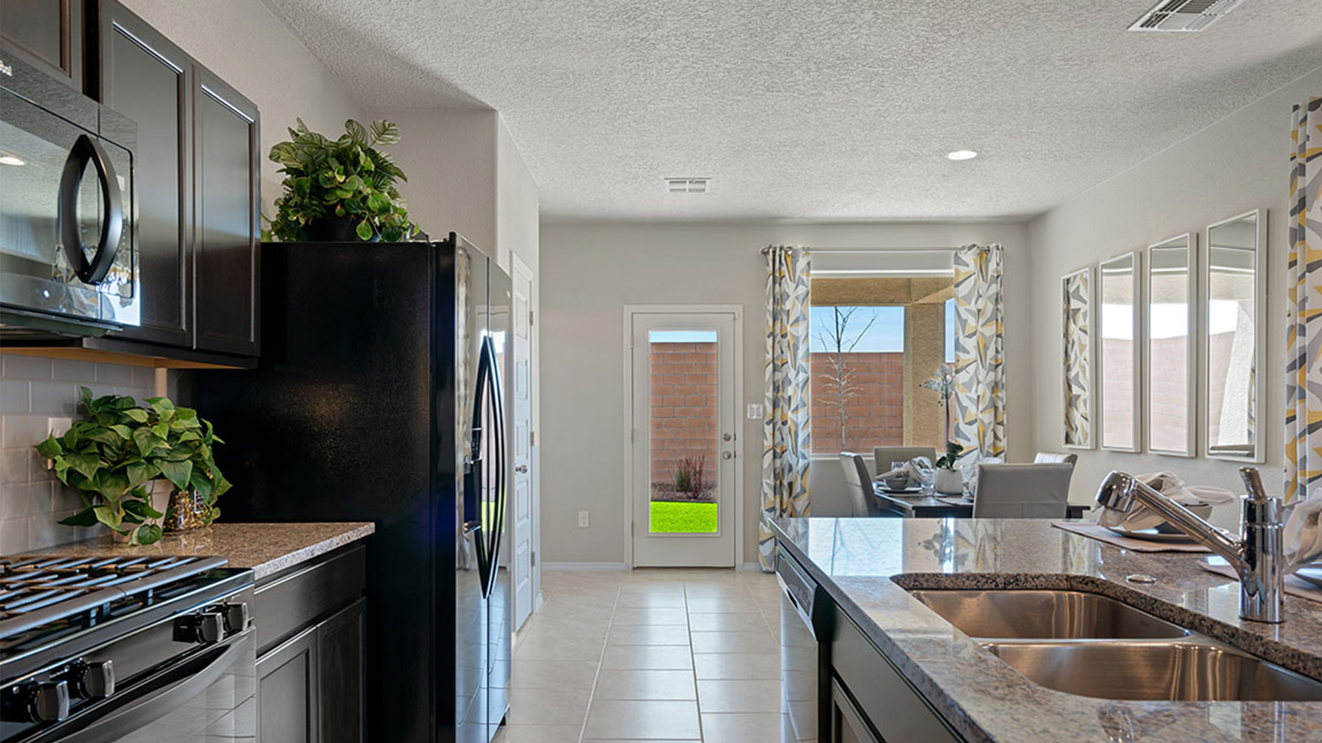 Dining area looking to kitchen and living room showing open floorflow and central gathering space at Los Diamantes Phase III