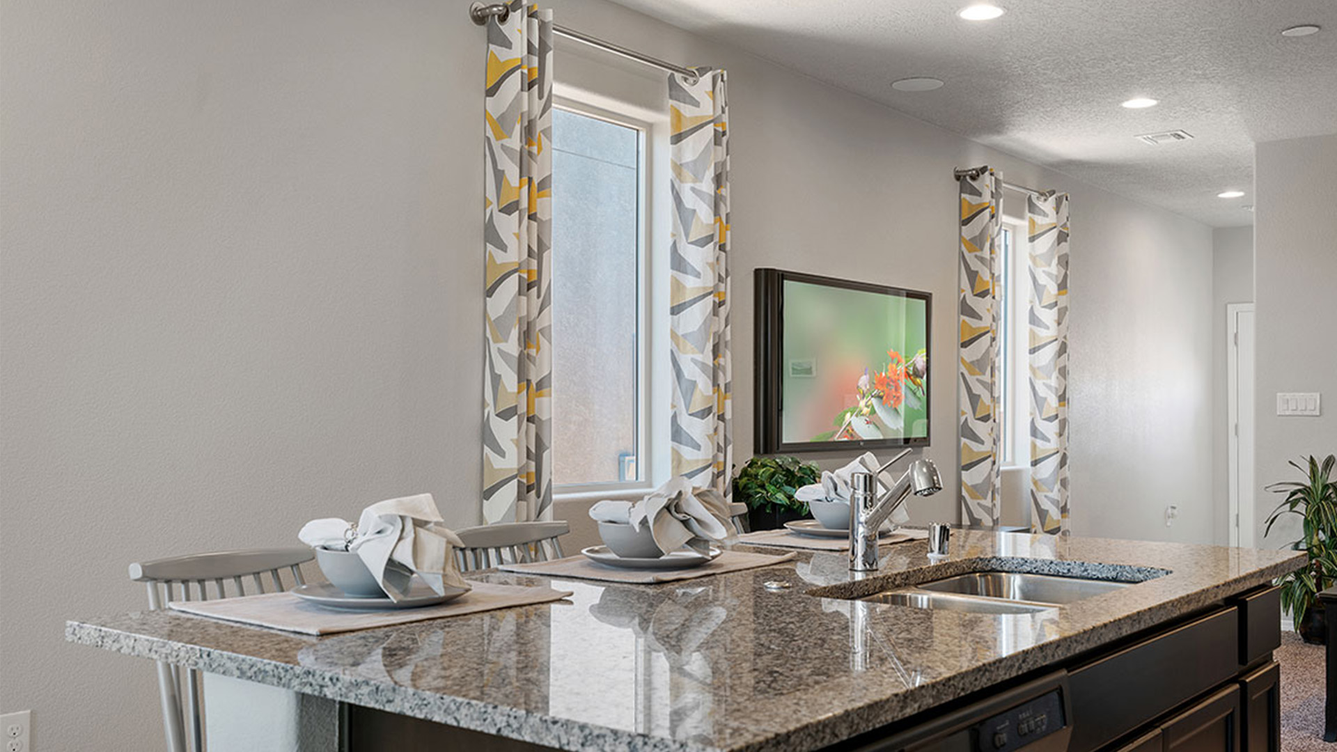 Kitchen island centered in gathering space providing prep surface and functional flow at Los Diamantes Phase III