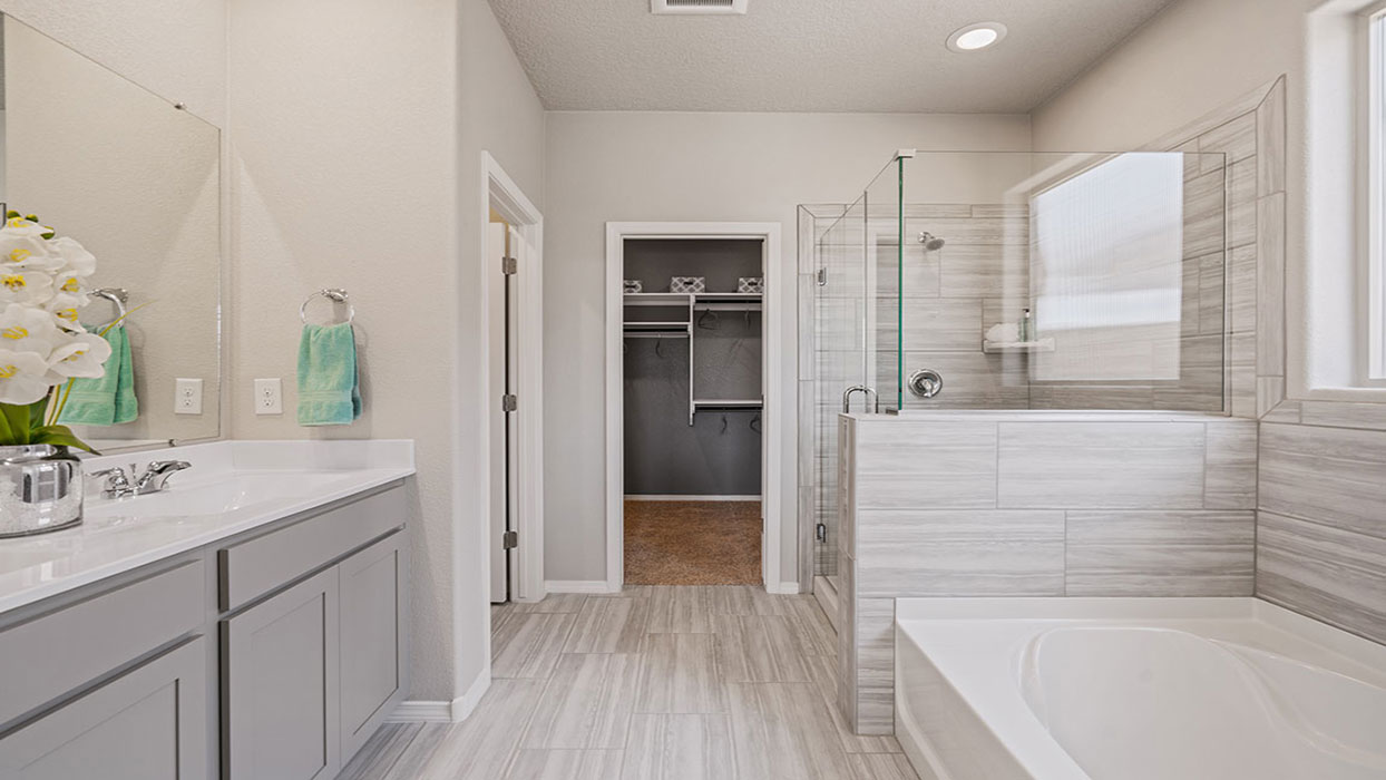 Walk-in shower with tile surround, glass enclosure, and upgraded fixtures at Los Diamantes Phase III
