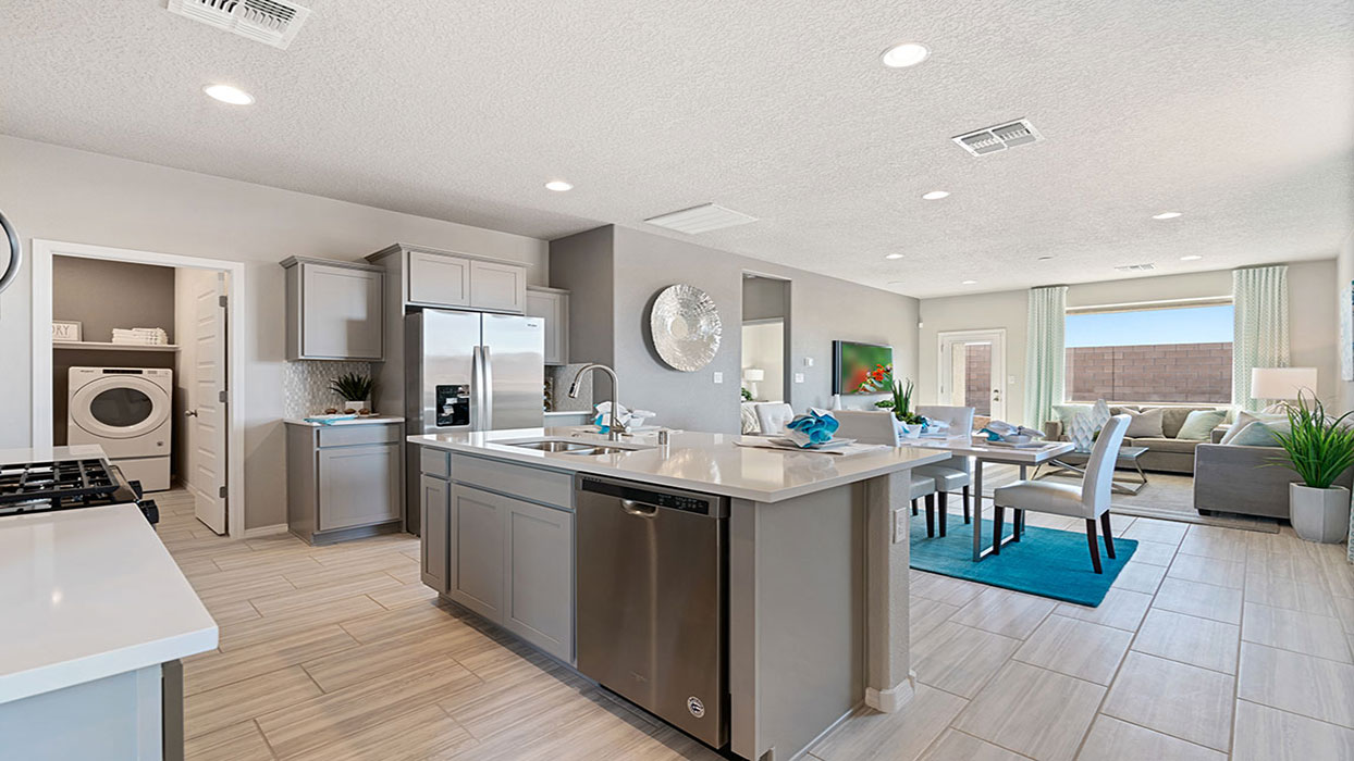 Kitchen looking toward dining and living areas showing open layout and full visibility across gathering spaces at Los Diamantes Phase III