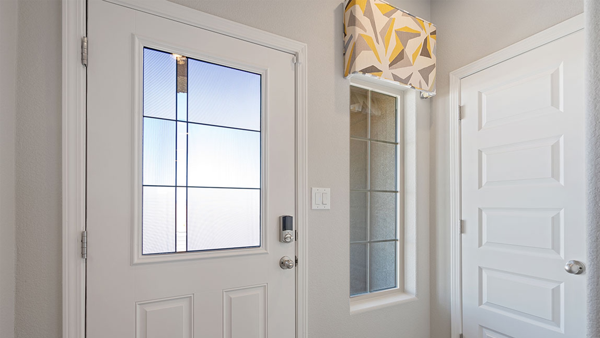 Fiesta Del Norte foyer with clean trim, rectangular entry light, and directional hallway access