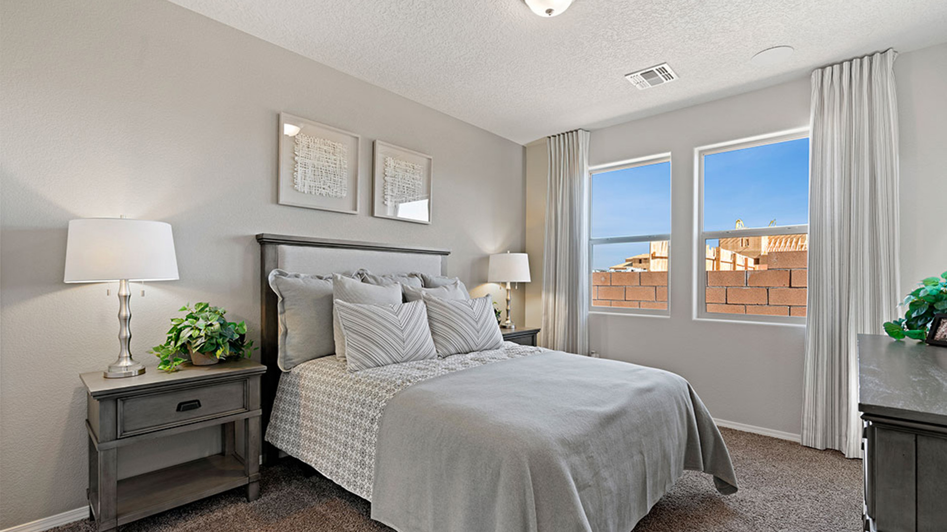 Bright and open primary bedroom in Fiesta Del Norte with neutral paint and large window in back of the residence