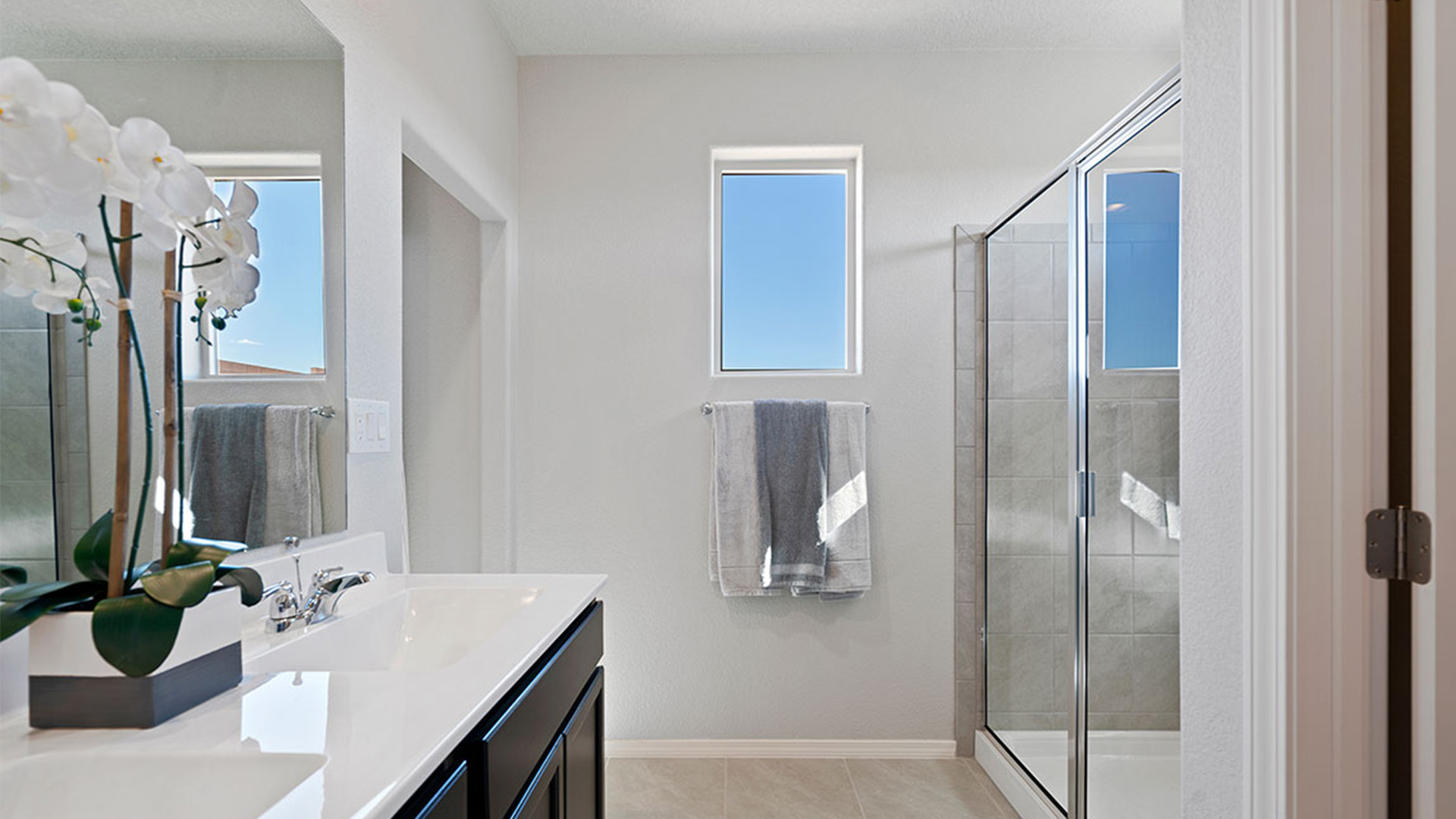 Spacious en suite bathroom by D.R. Horton featuring soft neutral tones, hard surface finishes, and dual sink design