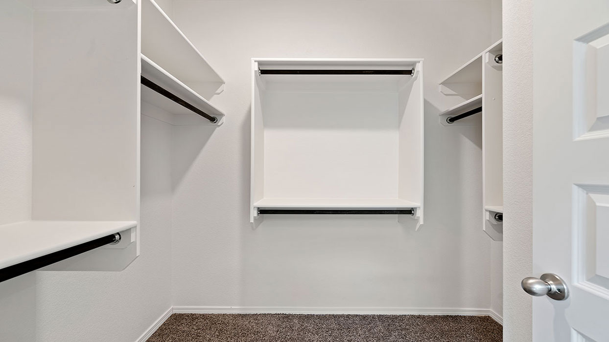 Primary suite walk-in closet view in Fiesta Del Norte   new home with built-in shelving and generous storage