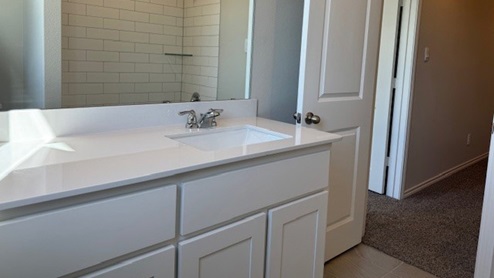 bathroom 2 with white cabinet and vanity