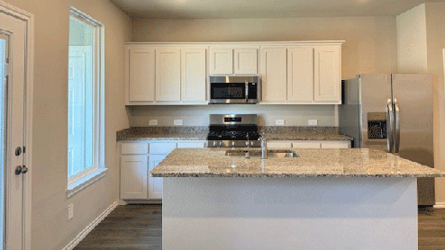 Kitchen with island, white cabinets and granite countertops