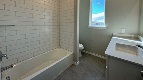 secondary bathroom with tub & vanity