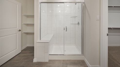 Interior primary bathroom with walk in shower and closet