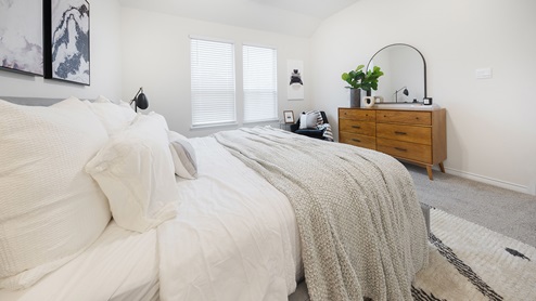 Interior bedroom with bright lighting and two large windows