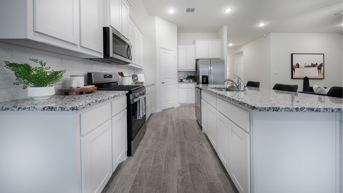 Interior kitchen with large central island and white cabinets