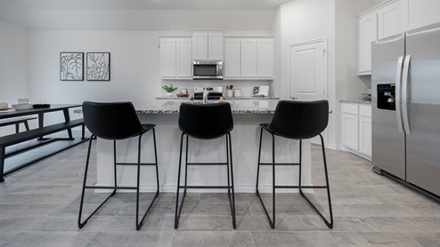 Interior kitchen with large central island and white cabinets
