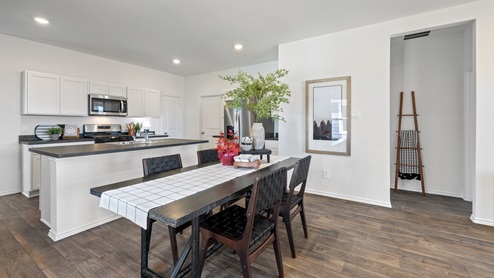 Dining area with kitchen adjacent and hall to bedrooms.