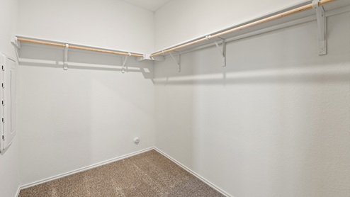 Spacious walk in closet with built in shelving in the primary bathroom.