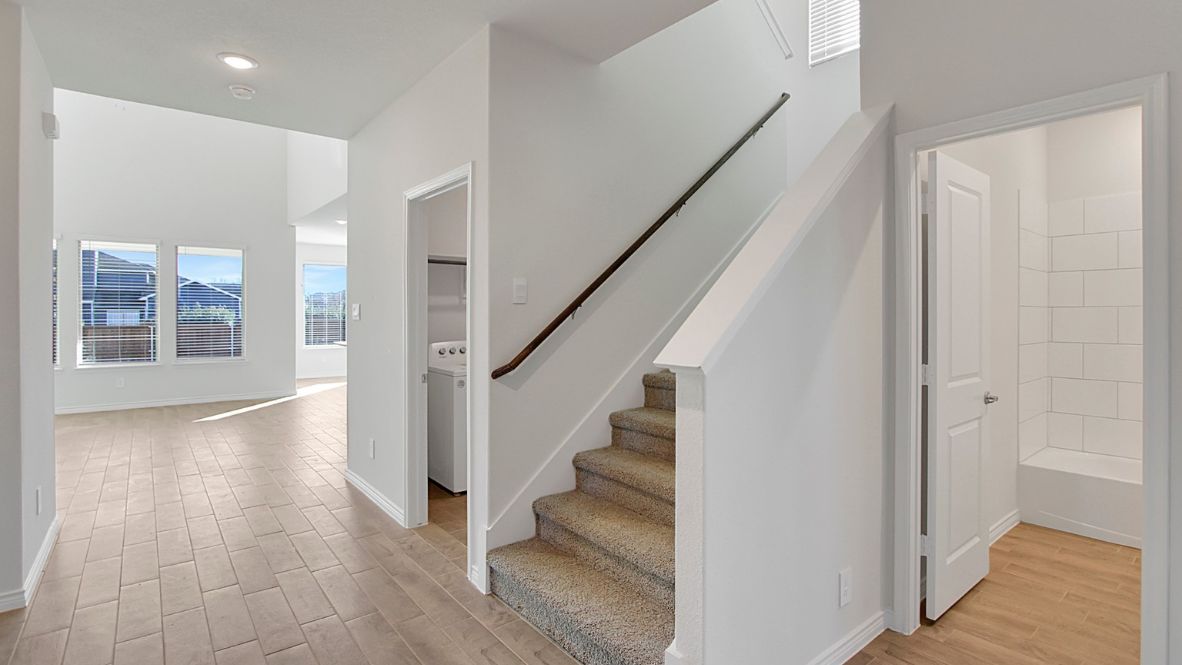 first floor stair case with wooden railing