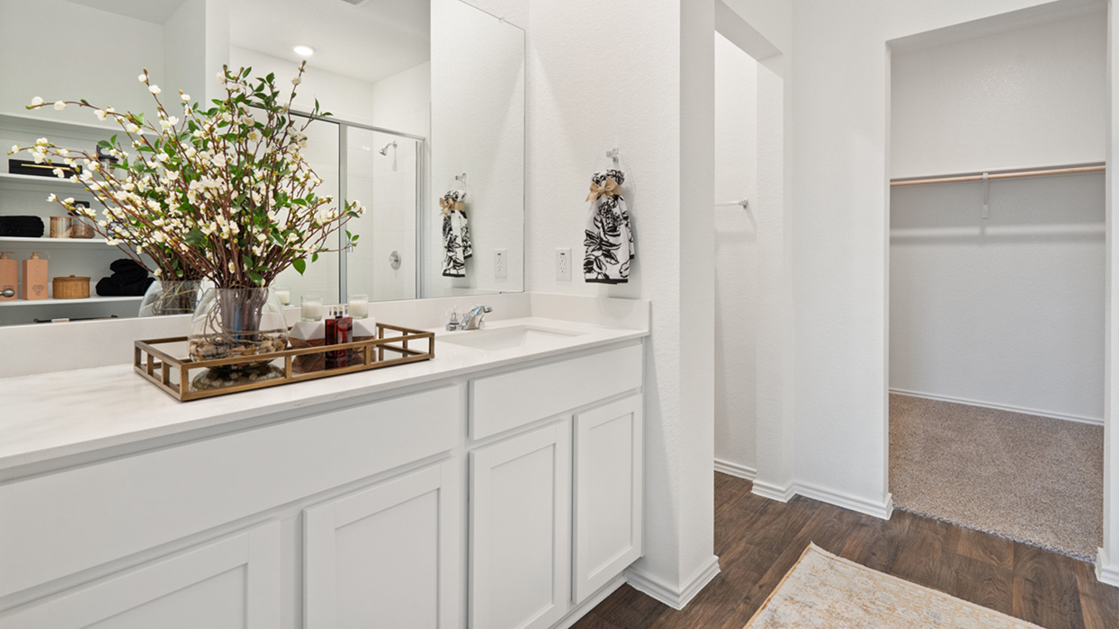 The primary bedroom ensuite is tucked away off the family room. Enjoy a peaceful start to your day in this space with the luxurious walk-in shower, double vanity, private toilet area with a door, and a large walk-in closet.
