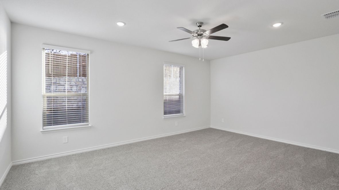 A spacious primary bedroom emphasizing open space and natural lighting.