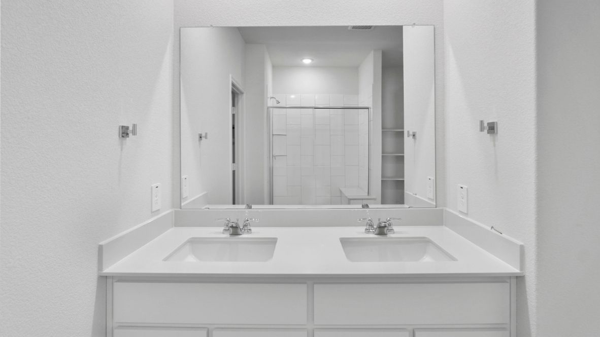 Spacious modern bathroom featuring a glass-enclosed shower, a large soaking tub with tiled surround and dual-sink vanity with sleek countertop. The layout includes a private water closet and a walk-in closet for added convenience, with natural light streaming through the window.