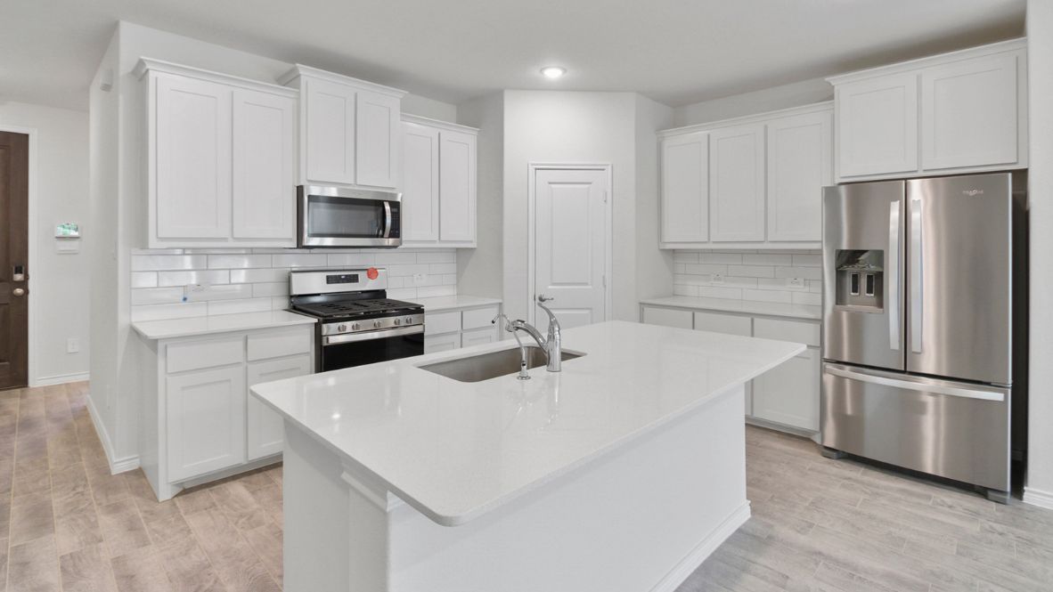Modern kitchen with white cabinetry, quartz countertops, stainless steel appliances, and a subway tile backsplash