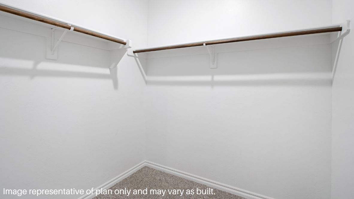 The primary bedroom can be entered through the family room. This bedroom features carpet floors and two bright windows, allowing for sunlight to adorn the room with its rays. The primary bedroom opens to the primary bathroom, complete with vinyl floors, a standing shower, a double sink, and a separate toilet room. The two carpeted walk-in closets on each side of the bathroom provide more than enough room for storage.