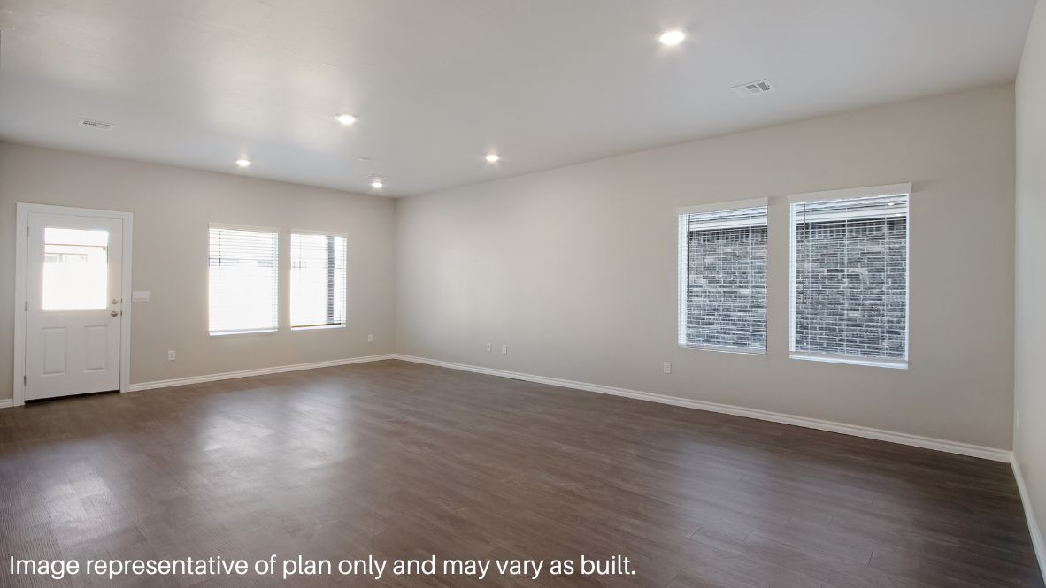 Continuing through the foyer, you will find the powder room, which is finished with vinyl flooring, and the carpeted stairway. The family room, dining room, and L-shaped kitchen are just beyond the staircase. This open concept living and dining space makes this house perfect for hosting football celebrations or large family gatherings. The vinyl flooring and bright windows allow the room to glow with natural lighting. The L-shaped kitchen is equipped with stainless-steel appliances, a large kitchen island, and a tall pantry. The utility room, which has vinyl flooring and space for a washer and dryer, can be accessed through the kitchen.