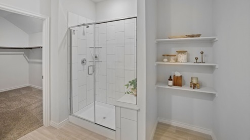 bathroom with dual vanity sinks, toilet, and a walk in shower