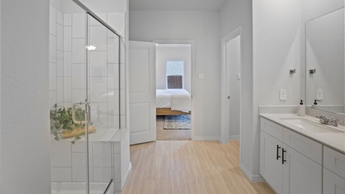 bathroom with dual vanity sinks, toilet, and a walk in shower