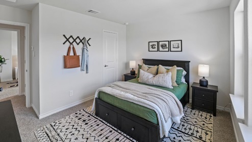 bedroom with beige carpet, grey walls and a window