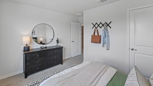 bedroom with beige carpet, grey walls and a window