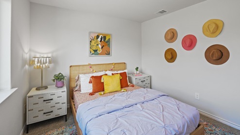 bedroom with beige carpet, white walls and a window