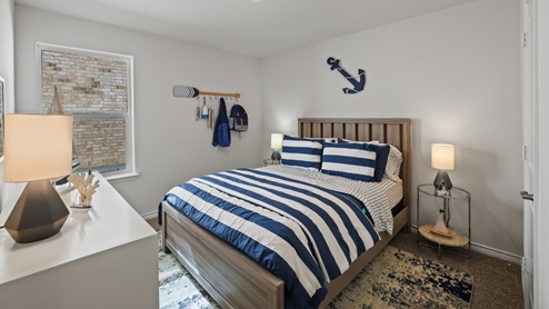bedroom with beige carpet, white walls and a window