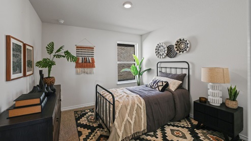 bedroom with beige carpet, white walls and a window