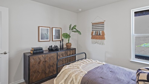 bedroom with beige carpet, white walls and a window