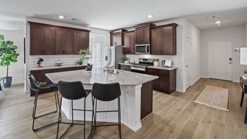 kitchen with brown cabinetry, large island and stainless steel appliances