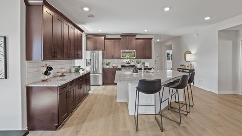 kitchen with brown cabinetry, large island and stainless steel appliances