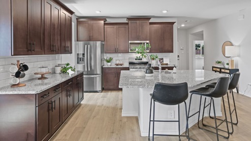 kitchen with brown cabinetry, large island and stainless steel appliances