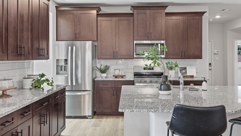 kitchen with brown cabinetry, large island and stainless steel appliances